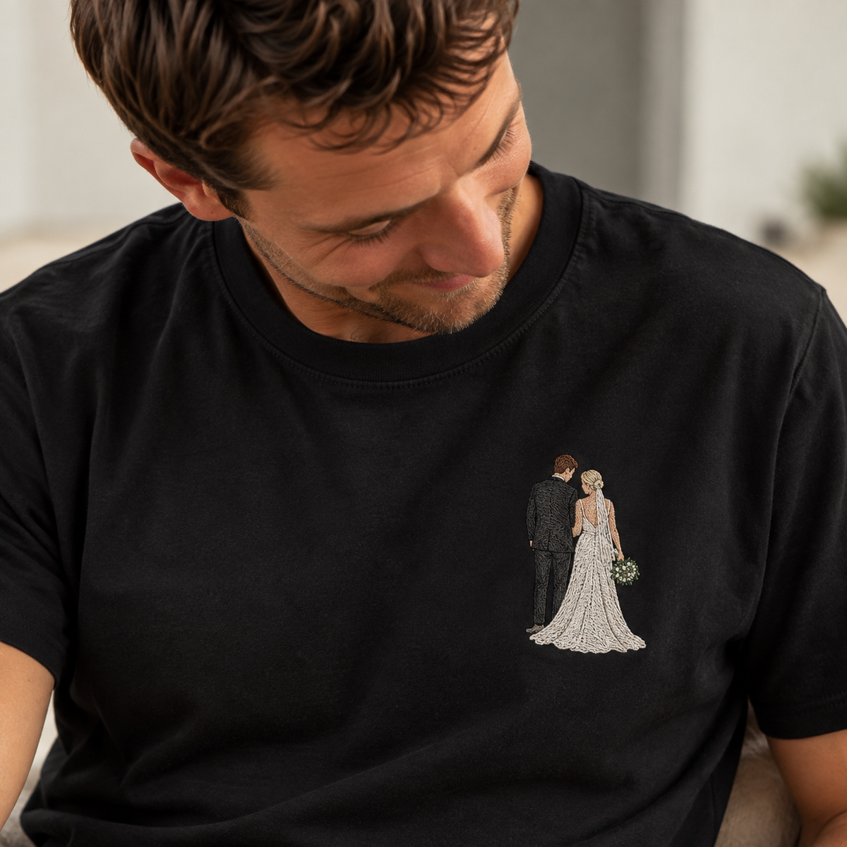 Man wearing a black personalised embroidered photo T-shirt with a small full-colour bride and groom wedding portrait