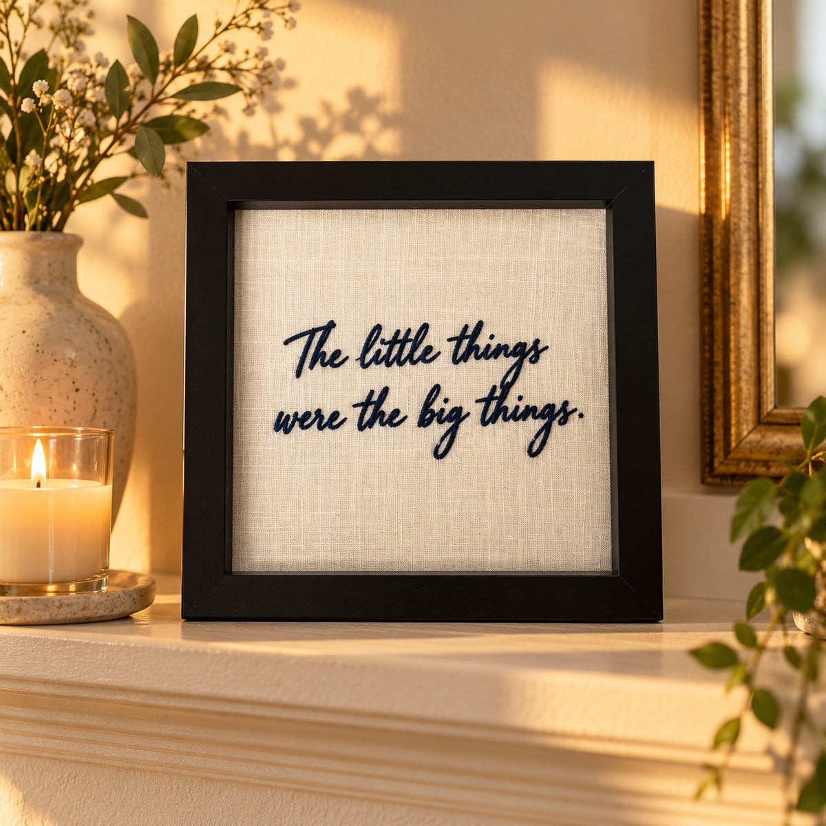 Custom navy embroidered message frame displayed on a mantelpiece with 'The little things were the big things'