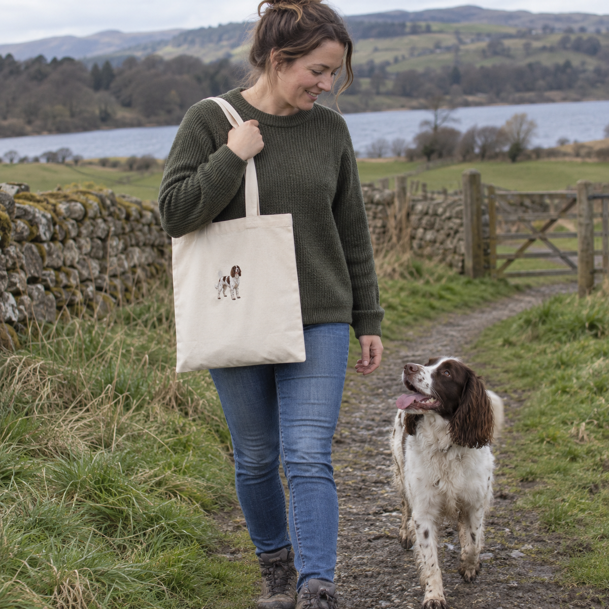 Woman carrying a natural personalised embroidered dog portrait tote bag with her Springer Spaniel on a countryside walk