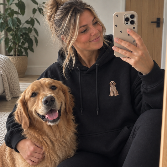 Woman wearing a jet black personalised embroidered pet portrait hoodie with a Golden Retriever in a natural UGC lifestyle photo