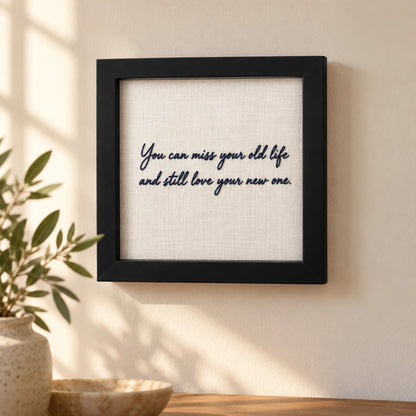 Personalised embroidered message frame hanging on a wall with navy handwritten quote about life's new beginnings