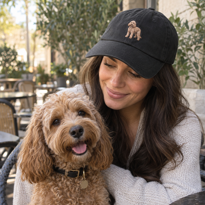 Woman wearing a black personalised embroidered pet portrait cap with a full-body curly dog embroidery in a natural lifestyle photo