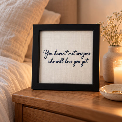 Black personalised embroidered handwriting frame on a bedside table with 'You haven't met everyone who will love you yet'