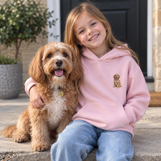 Girl wearing a personalised embroidered kids pet portrait hoodie in pink with her dog in a natural UGC-style outdoor photo