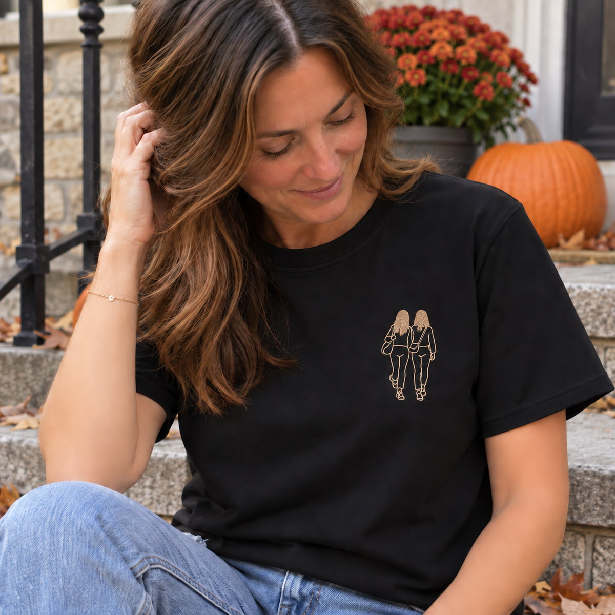 Woman wearing a black personalised outline embroidered T-shirt with a small single-colour two-person friendship design and filled hair