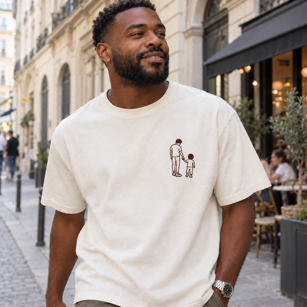 Man wearing a personalised outline embroidered T-shirt with a small single-colour father and child holding hands design and filled hair