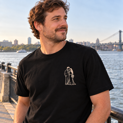 Man wearing a black personalised outline embroidered T-shirt with a small single-colour bride and groom wedding design with filled hair