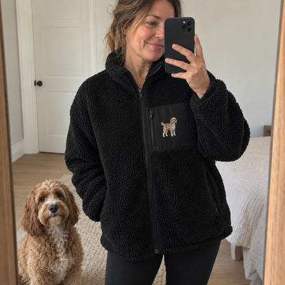 Woman wearing a black personalised pet portrait sherpa fleece in a mirror selfie with a doodle embroidery on the chest pocket