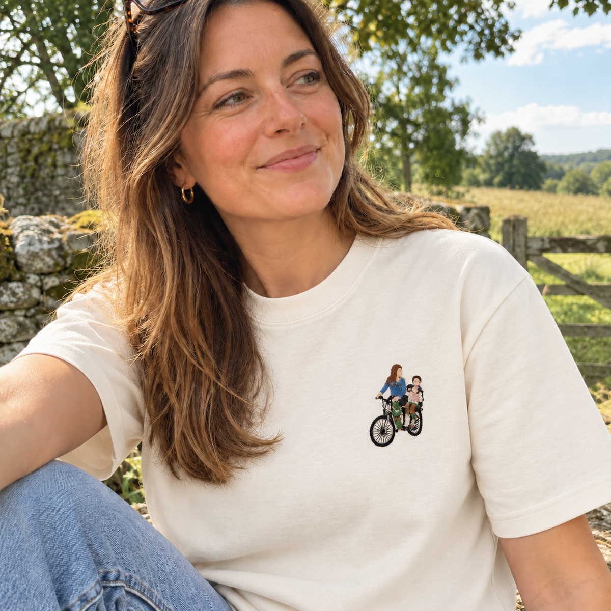 Woman wearing an off-white personalised embroidered photo T-shirt with a small full-colour cycling memory design outdoors