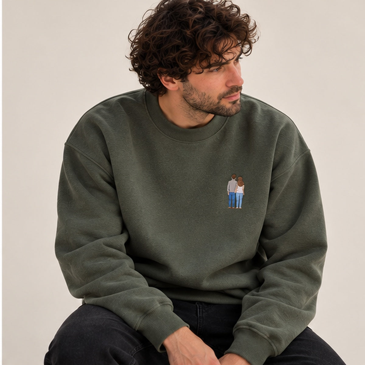 Man wearing an earthy green heavyweight signature sweater with small embroidered couple photo design